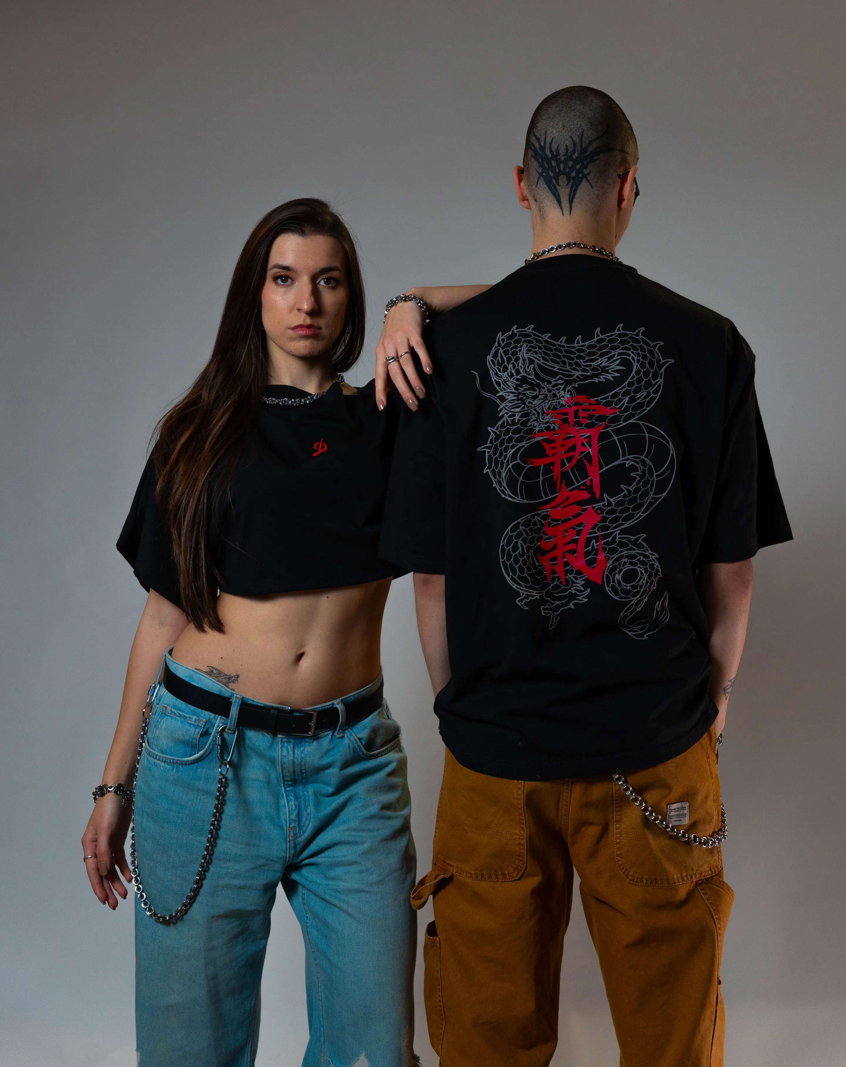 Full lengths — cropped tee and chained jeans beside ochre carpenter pants