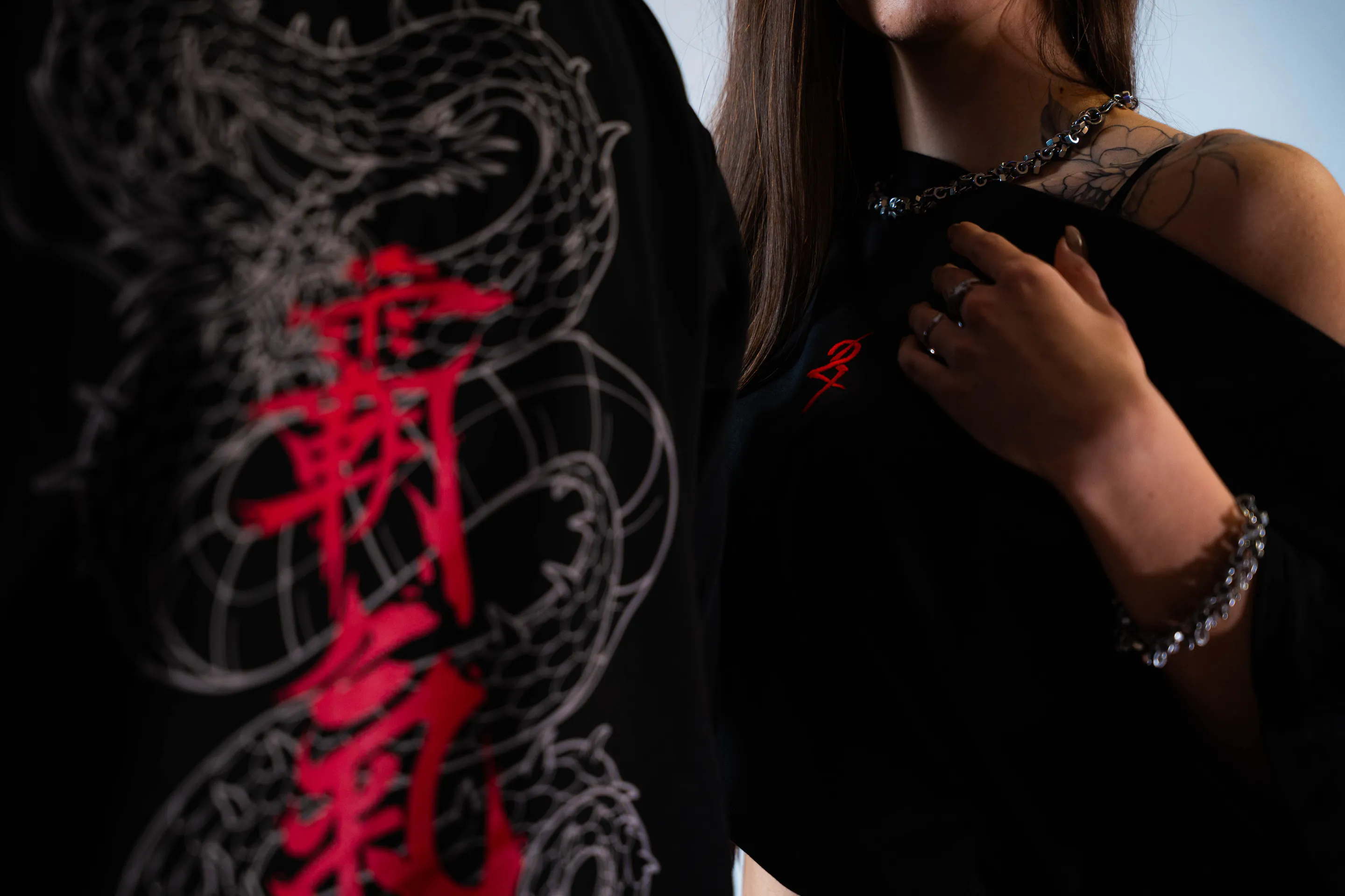 Sleeve dragon and red kanji, her hand at the necklace
