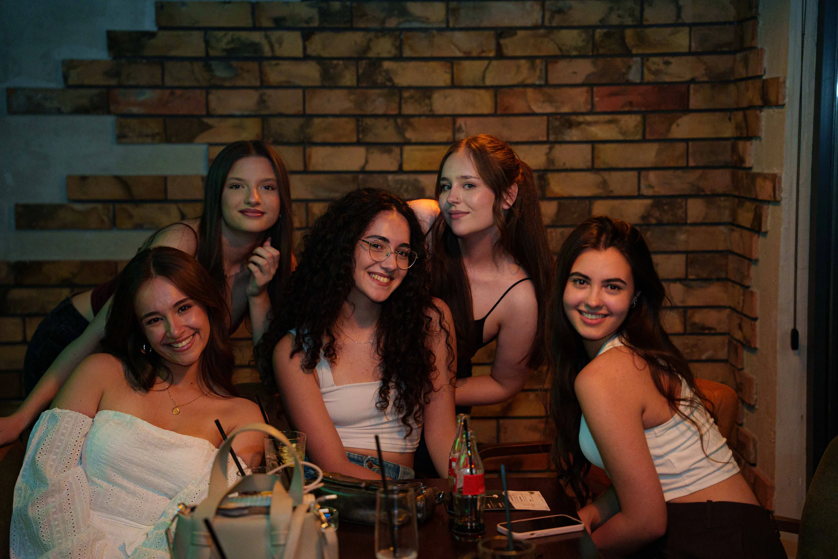 A table of six against the brick wall, drinks in