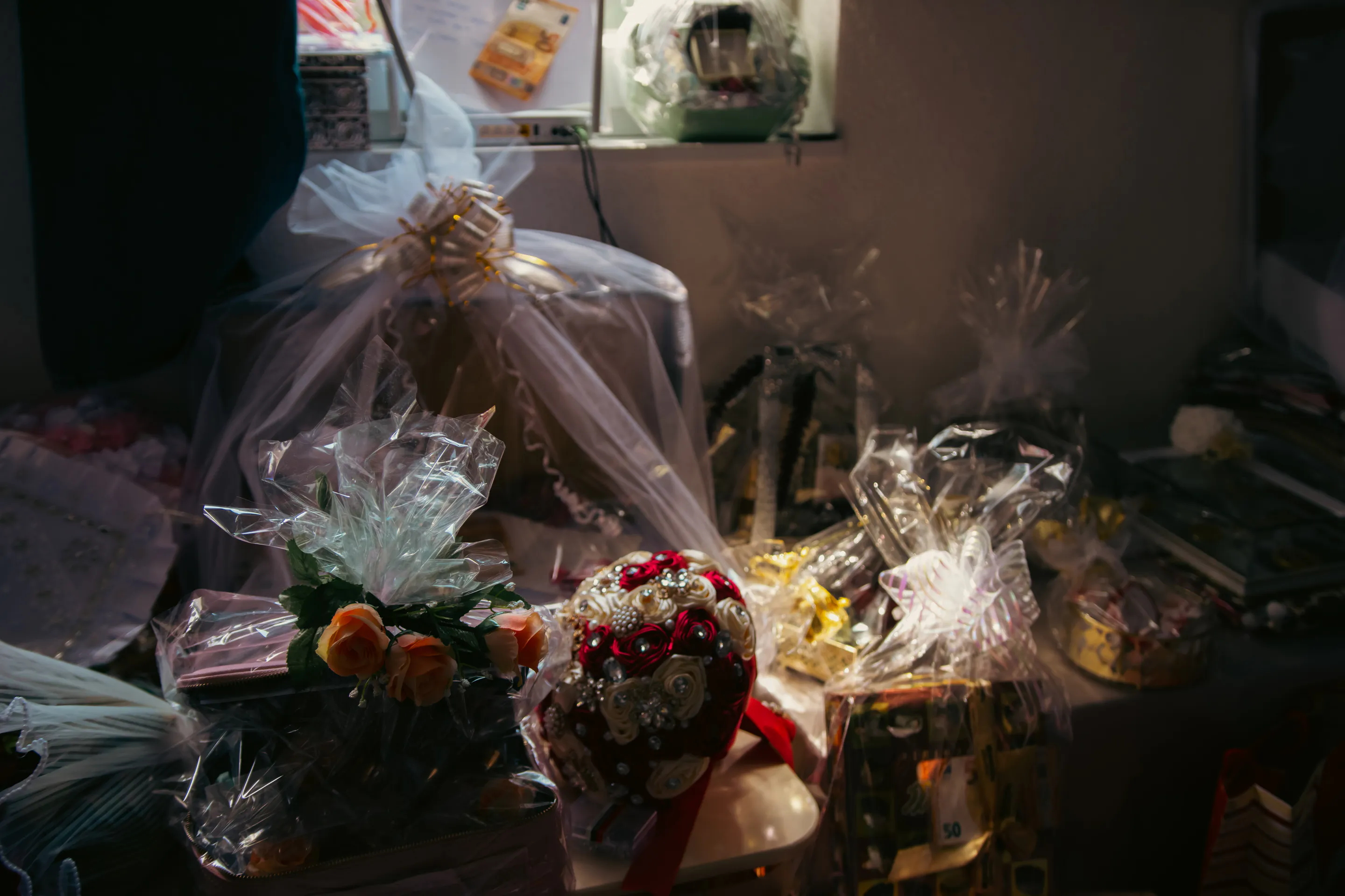 Gifts wrapped in tulle and cellophane crowding a low-lit table