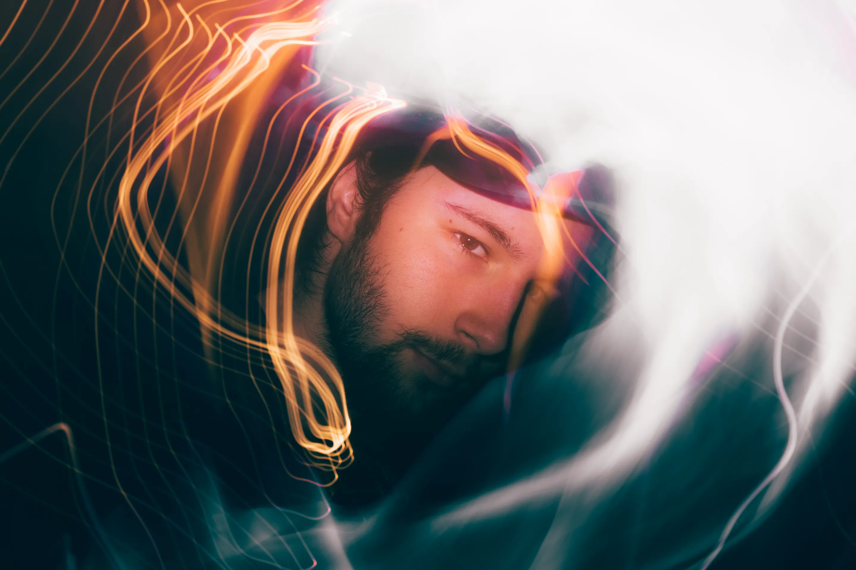A face caught inside swirling long-exposure light trails